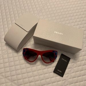 GUC red Prada sunglasses with blue gems.